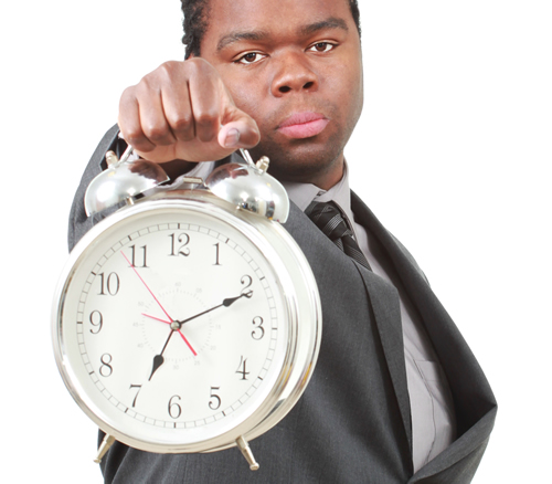 Image of a stern looking man holding a retro alarm clock